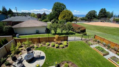 A healthy new seeded lawn feels expanded with the borrowed view of the baseball field